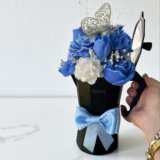 Cafetera negra con ramo de cera en color azul y aromas florales