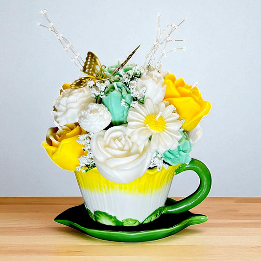 Ramo de cera en taza y plato decorativo.